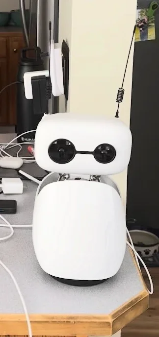 Neural Bot, a white arm-free Reachy Mini, on a workbench